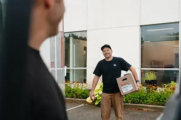 Installateur souriant avec une boite sous le bras